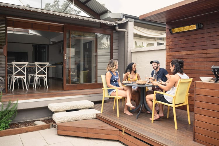 People enjoying the warmth of Electric Patio Heaters at an outdoor table on a patio