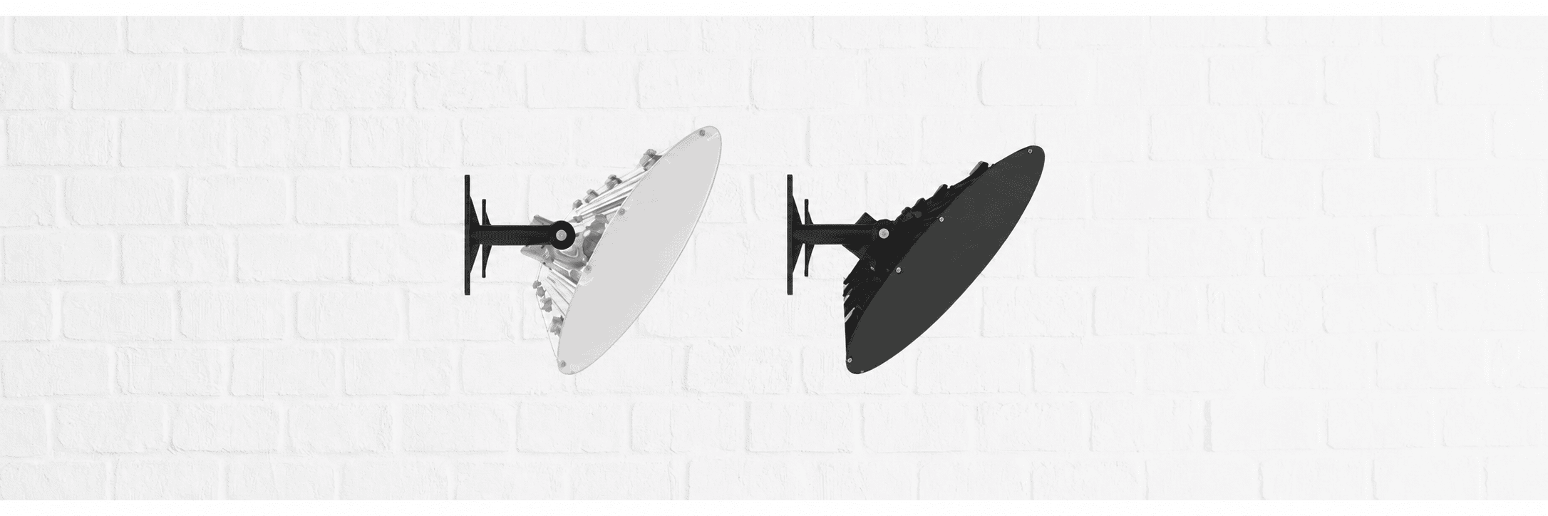 White and black Aura infrared heaters mounted on a wall at adjustable angles